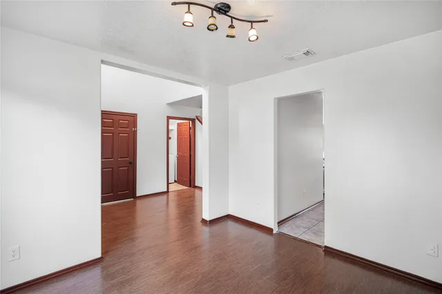a view of an empty room with wooden floor