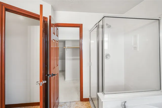 a bathroom with a shower and a glass shower door