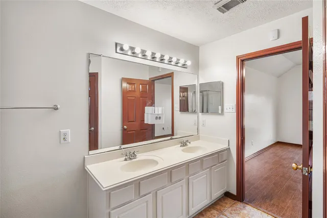 a bathroom with a double vanity sink and mirror