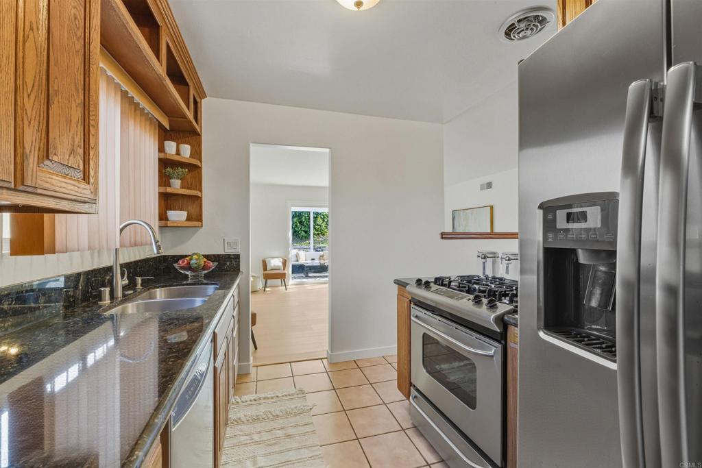 9909 Halberns Boulevard Santee, CA 92071 - Photo 12 of 35 a kitchen with stainless steel appliances granite countertop a stove a sink and a refrigerator