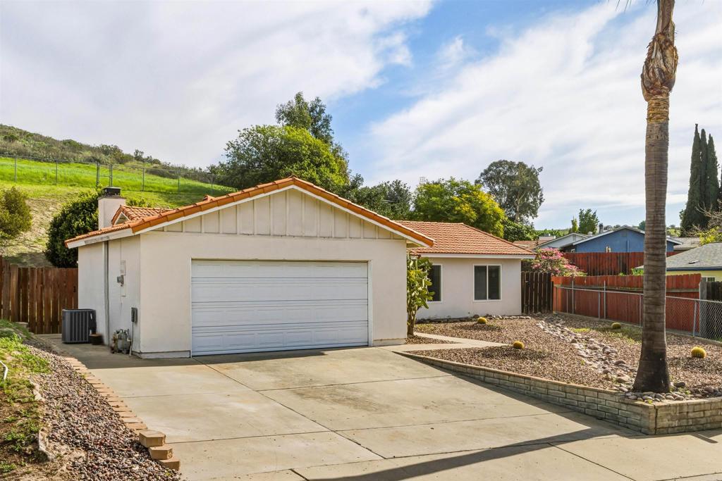 9909 Halberns Boulevard Santee, CA 92071 - Photo 34 of 35 a view of a white house with a yard and table and chairs under an umbrella