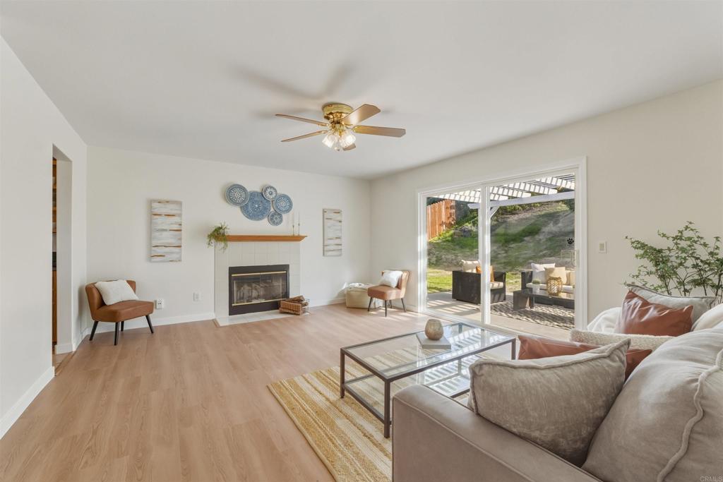 9909 Halberns Boulevard Santee, CA 92071 - Photo 5 of 35 a living room with furniture a fireplace and a floor to ceiling window