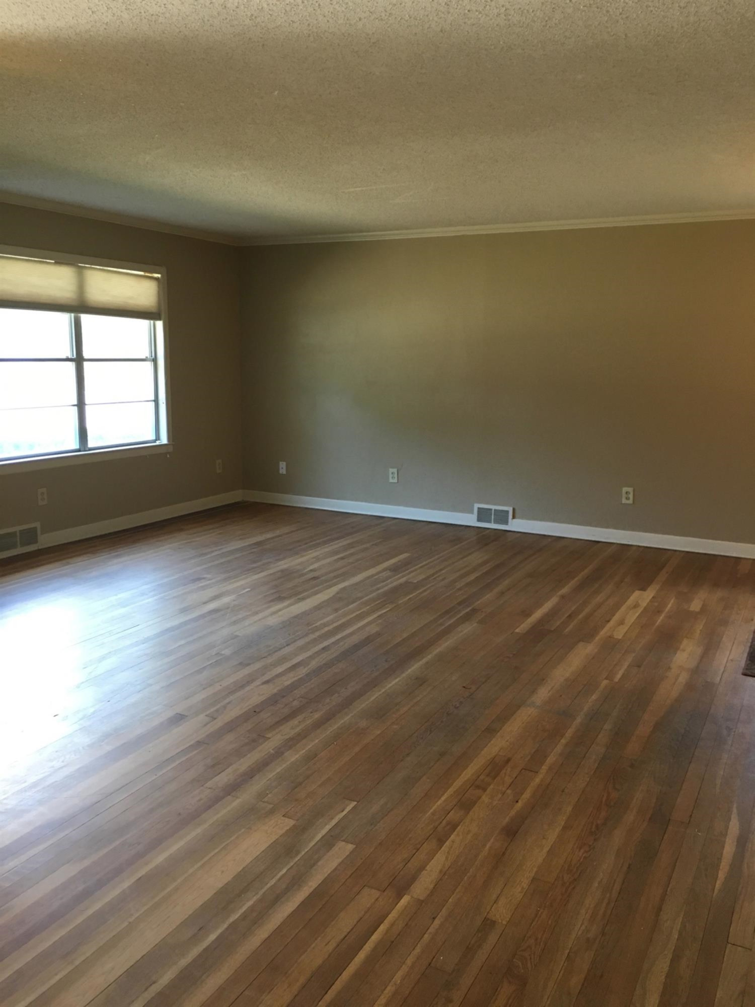 2801 20th Street Lubbock, TX 79410 - Photo 5 of 10 a view of an empty room with wooden floor and a window
