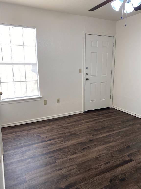 1110 Williams, Unit A Cleburne, TX 76033 - Photo 2 of 6 an empty room with wooden floor and windows