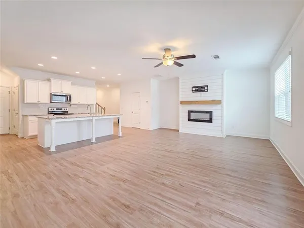 a large kitchen with stainless steel appliances granite countertop a lot of counter space and wooden floor