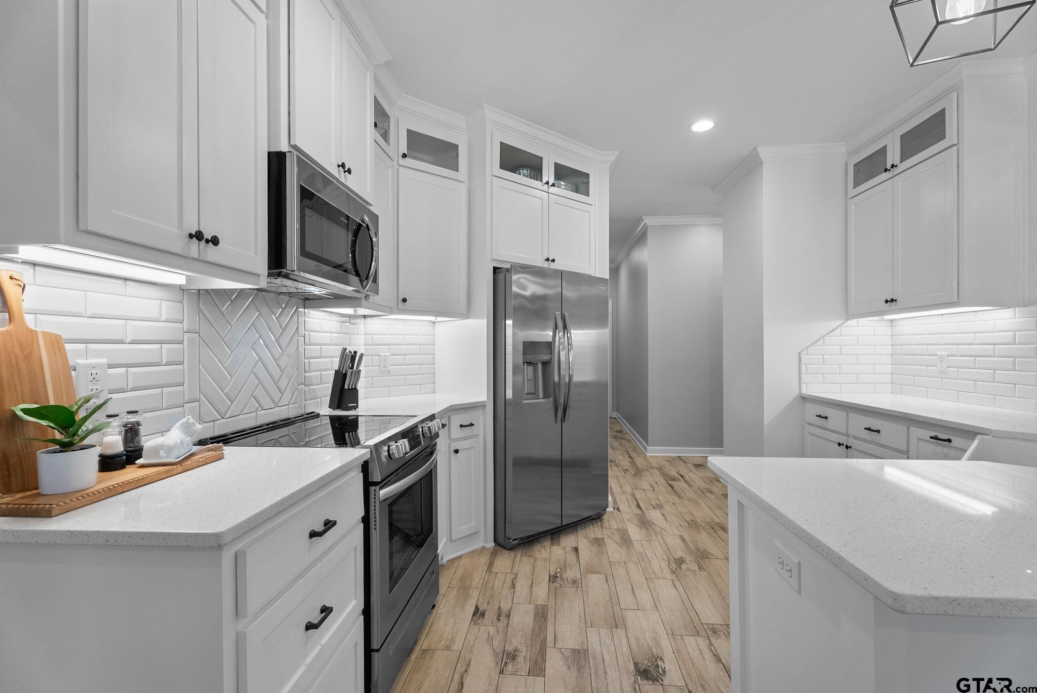 14543 Fallow Lane Tyler, TX 75706 - Photo 11 of 32 a kitchen with stainless steel appliances a sink a stove a microwave a sink a refrigerator and cabinets