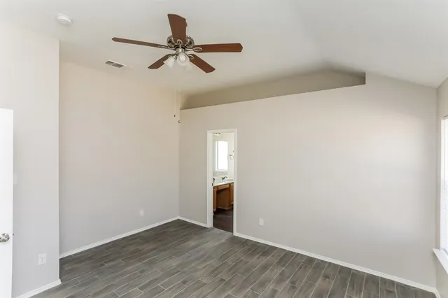 a view of a room with wooden floor and a ceiling fan