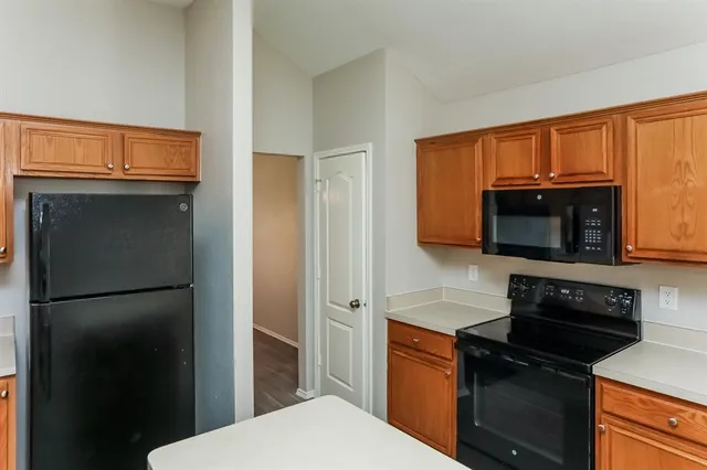 a kitchen with stainless steel appliances granite countertop a refrigerator and a stove top oven