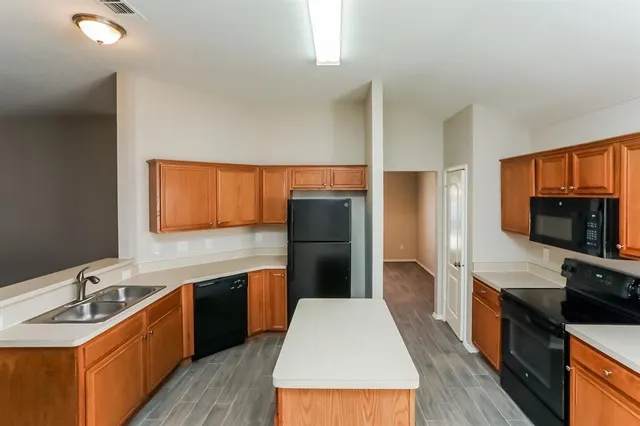 a large kitchen with a stove a sink and a refrigerator