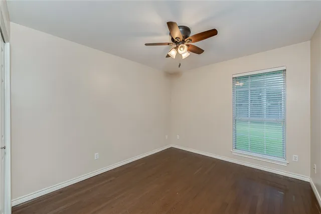 a view of a big room with wooden floor and windows