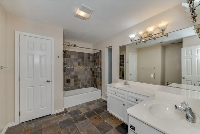 a bathroom with double vanity sink and a mirror