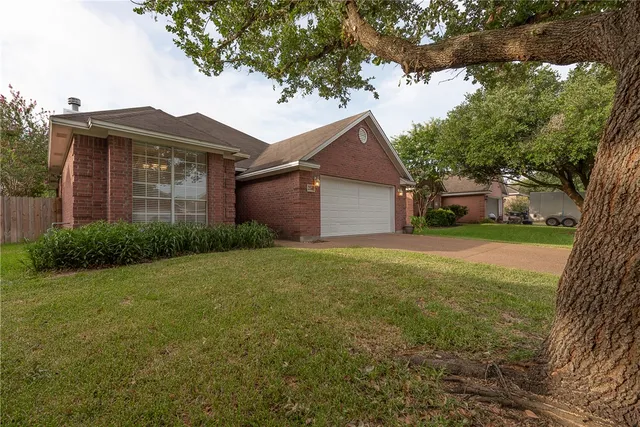 a front view of house with yard and trees around