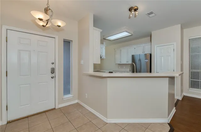 a view of kitchen with granite countertop cabinets and refrigerator