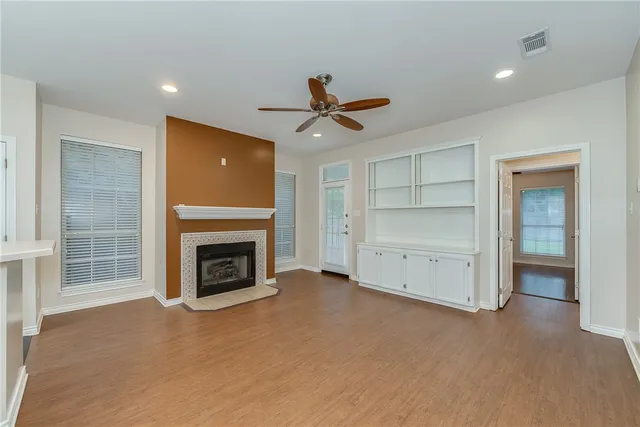 a view of a livingroom with a fireplace closet and windows
