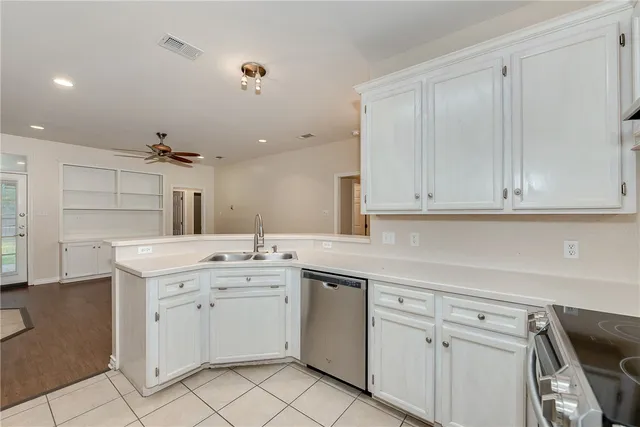 a kitchen with white cabinets and sink