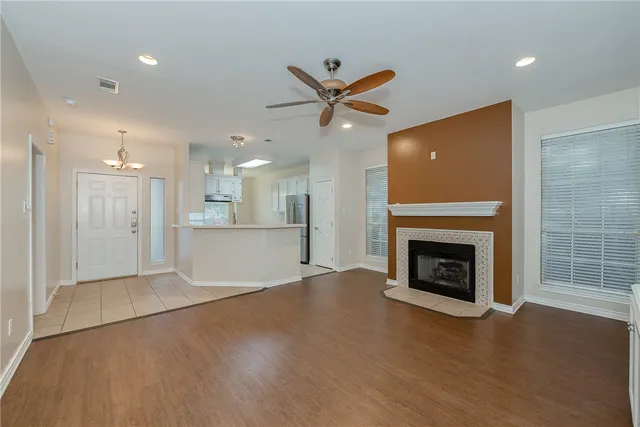 a view of an empty room with a fireplace and a window