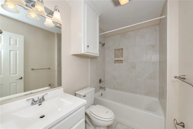 a bathroom with a bathtub shower sink vanity and toilet