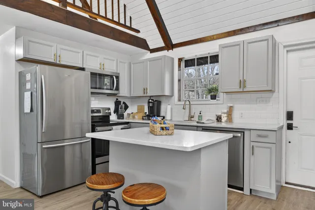 a living room with furniture a rug and wall paintings