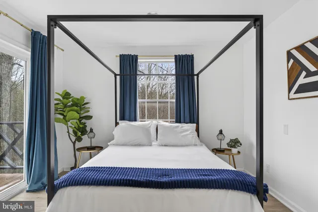 a view of a roof deck with table and chairs couches with wooden floor and fence
