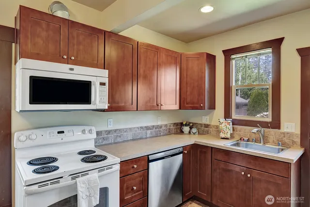 a kitchen with a sink a stove and cabinets