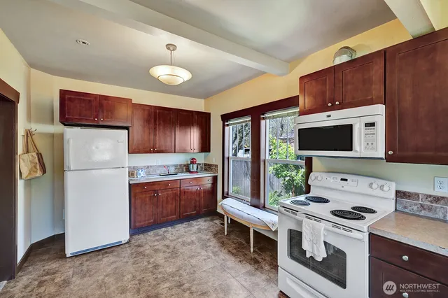 a kitchen with stainless steel appliances a stove a refrigerator and a fireplace