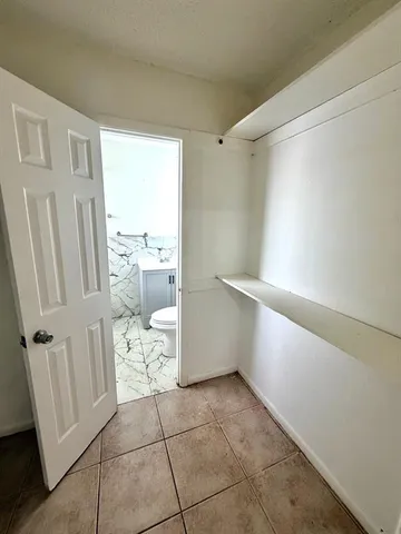 a kitchen with stainless steel appliances granite countertop a stove a sink dishwasher and white cabinets with wooden floor