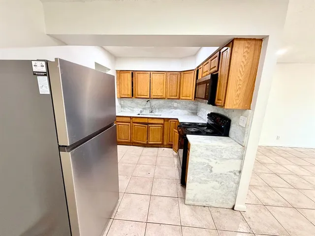 a kitchen with granite countertop a refrigerator and a sink