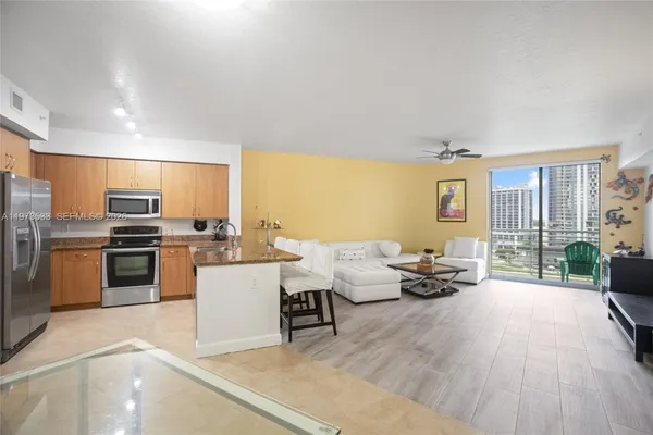 a living room with couches and kitchen view with wooden floor