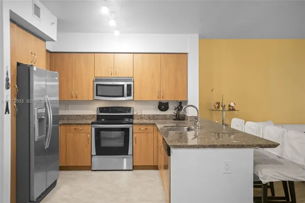 a kitchen with stainless steel appliances granite countertop a sink stove and refrigerator