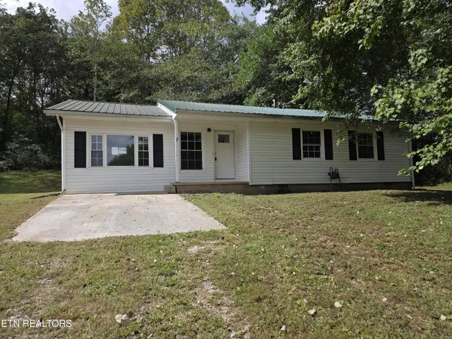 a front view of a house with yard and trees