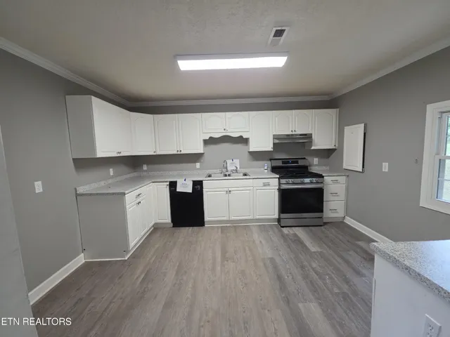 a kitchen with stainless steel appliances granite countertop a stove sink and cabinets