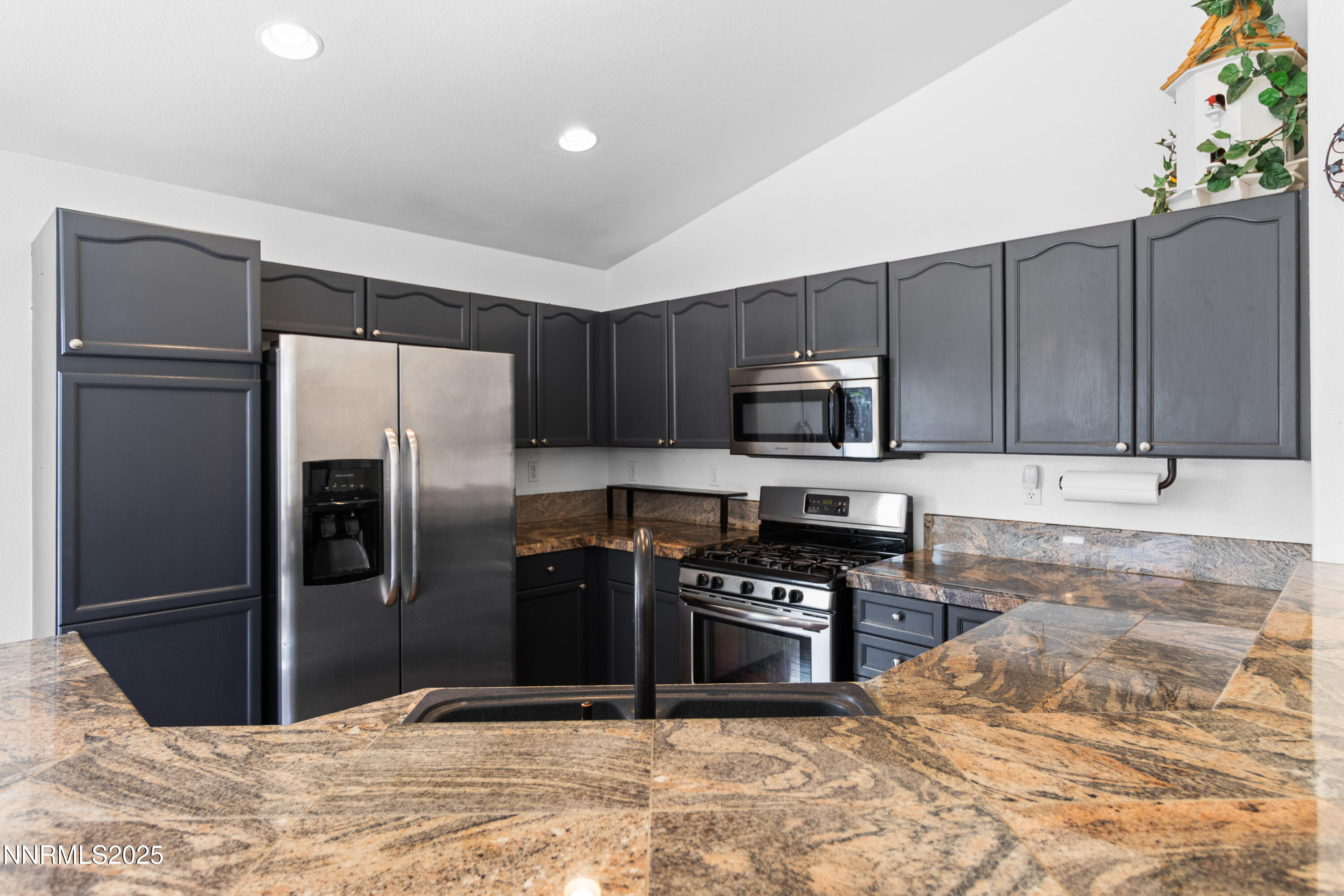 10375 Rosemount Drive Reno, NV 89521 - Photo 15 of 29 a kitchen with granite countertop a refrigerator and a stove top oven
