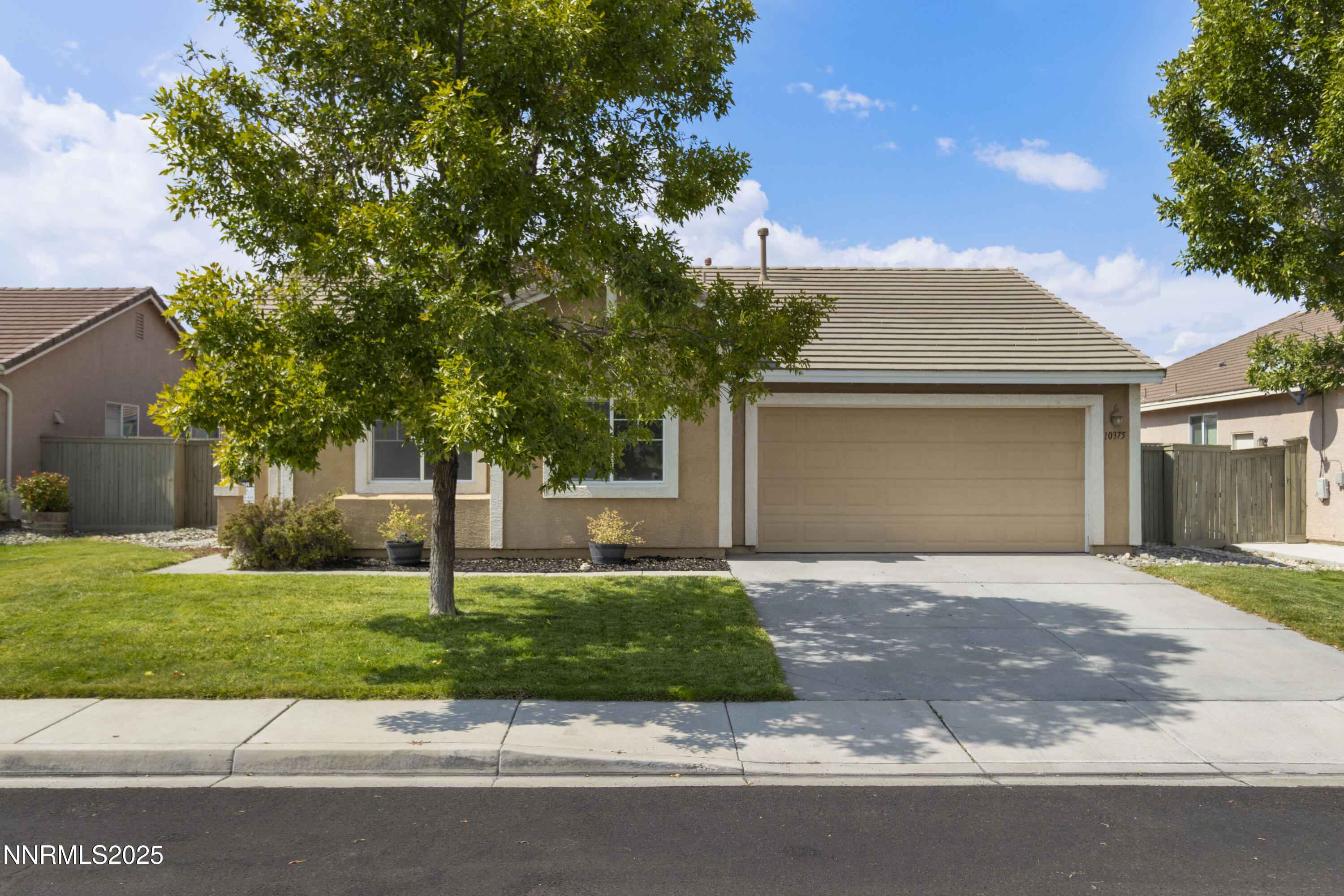 10375 Rosemount Drive Reno, NV 89521 - Photo 3 of 29 a front view of a house with a garden and trees