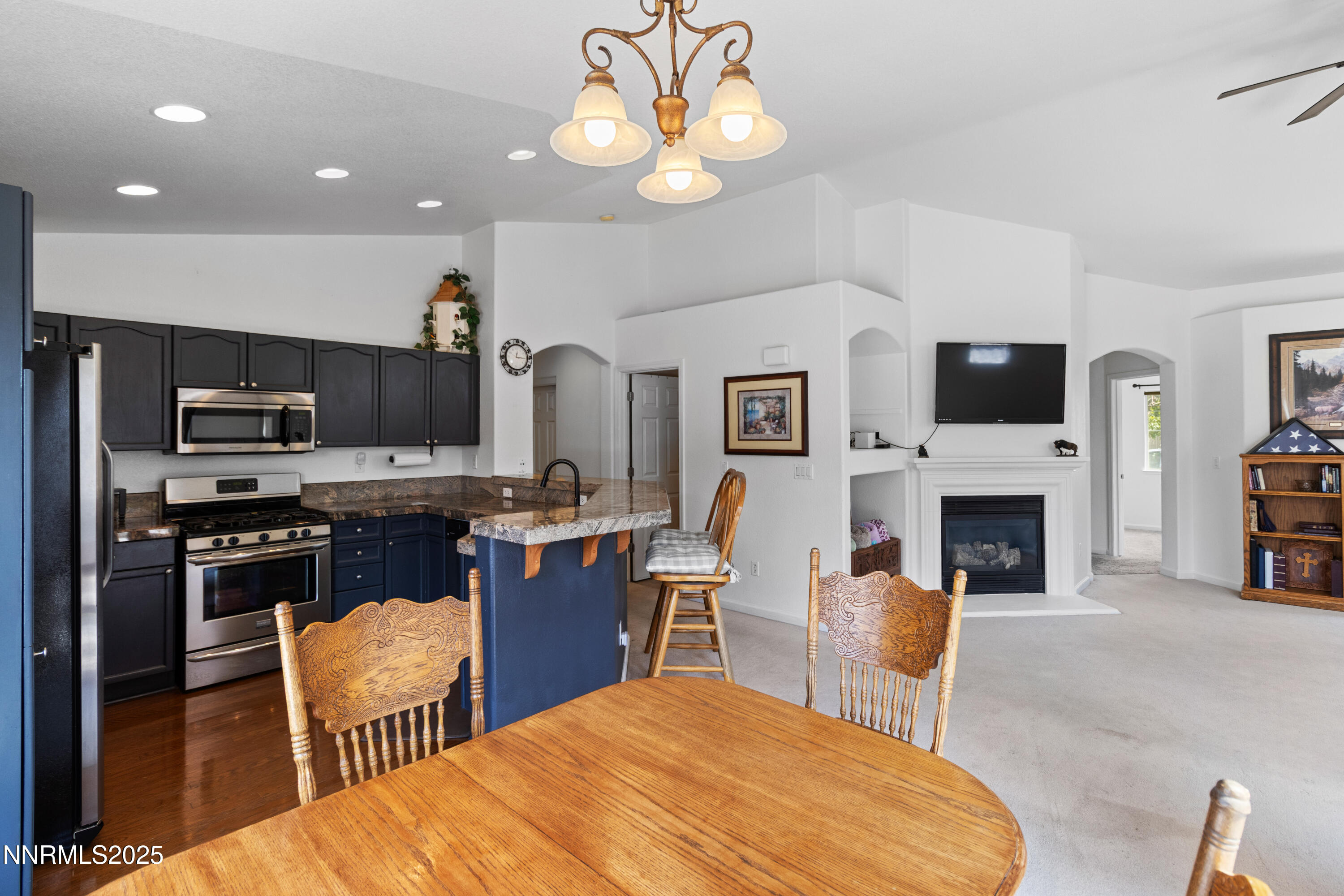 10375 Rosemount Drive Reno, NV 89521 - Photo 6 of 29 a large kitchen with stainless steel appliances granite countertop a stove top oven a sink dishwasher and a fireplace with wooden floor