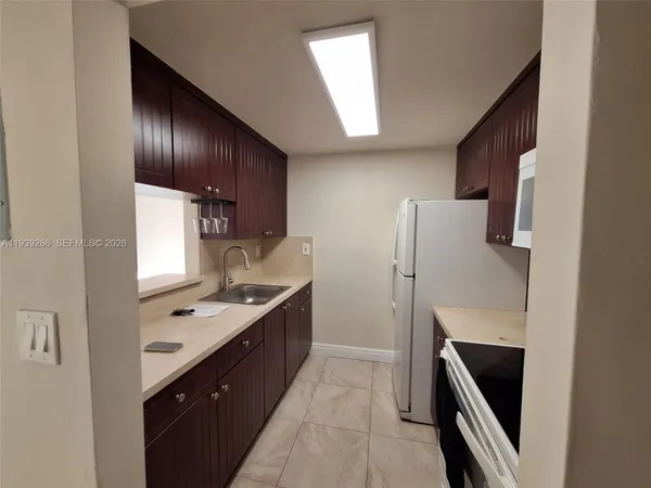 a kitchen with a sink a refrigerator and cabinets
