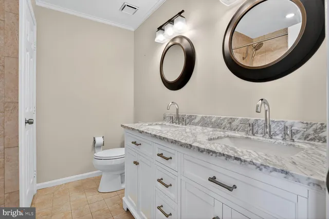 a bathroom with a granite countertop toilet a sink and a mirror