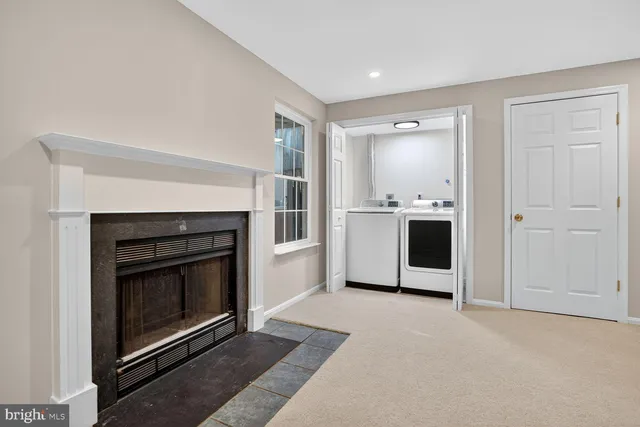 a living room with stainless steel appliances wooden floor and a fireplace