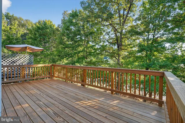 a balcony with wooden floor and trees in the back