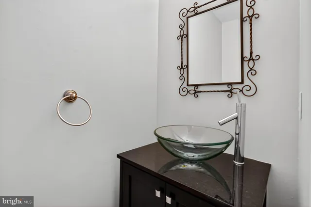 a bathroom with a granite countertop toilet a mirror and vanity