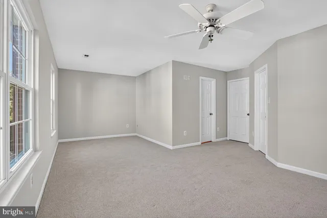 a view of an empty room with a ceiling fan