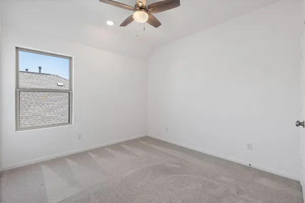 an empty room with a window and a fan