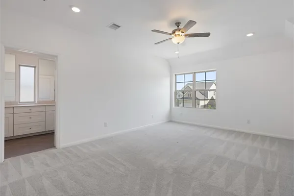 an empty room with fan and windows