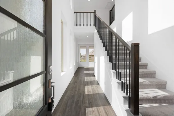 a view of a hallway with wooden floor and entryway