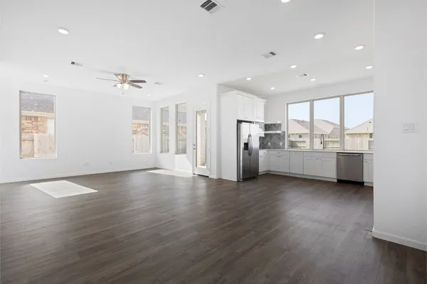a view of a kitchen with refrigerator and wooden floor