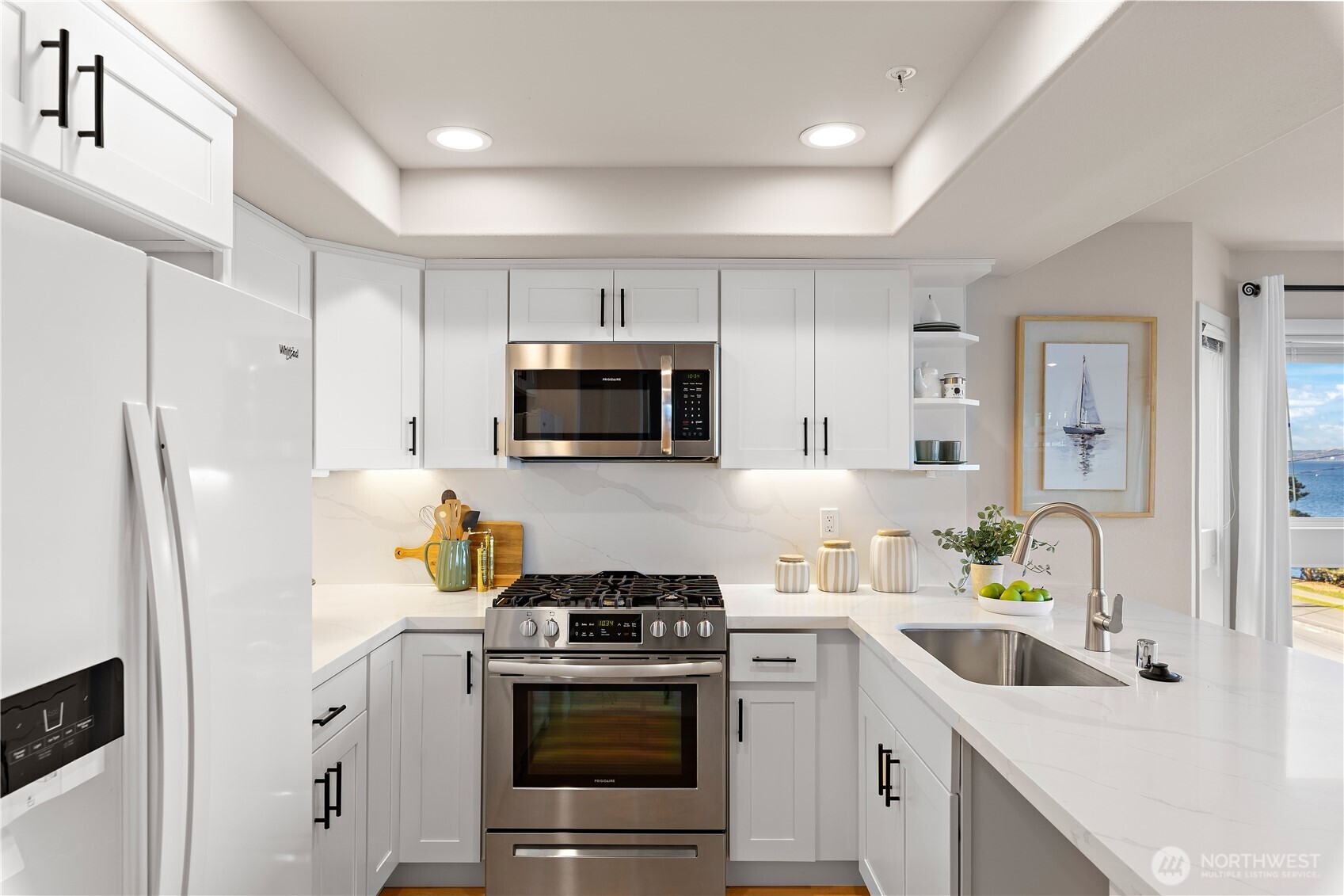 1300 Alki Avenue Southwest, Unit 200 Seattle, WA 98116 - Photo 13 of 32 a kitchen with stainless steel appliances a white cabinets wooden floor and a sink