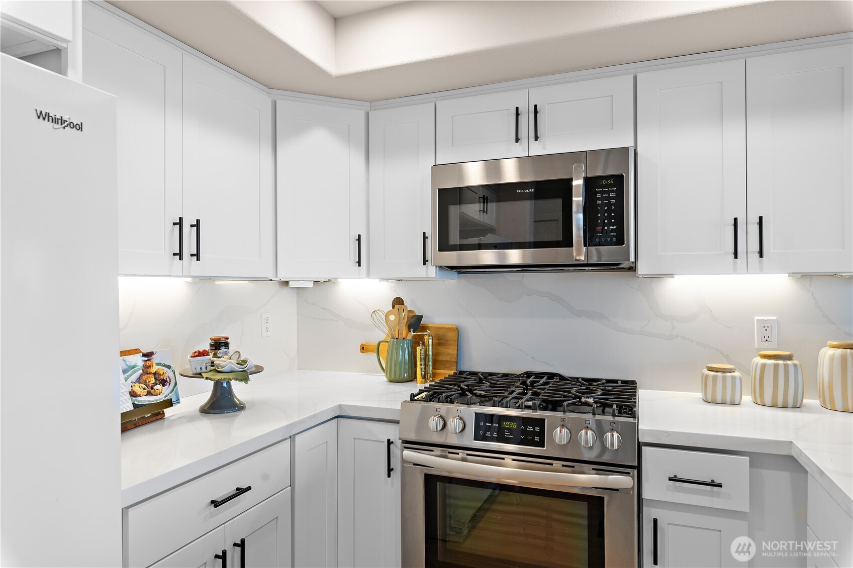 1300 Alki Avenue Southwest, Unit 200 Seattle, WA 98116 - Photo 14 of 32 a kitchen with cabinets stainless steel appliances a sink and wooden floor