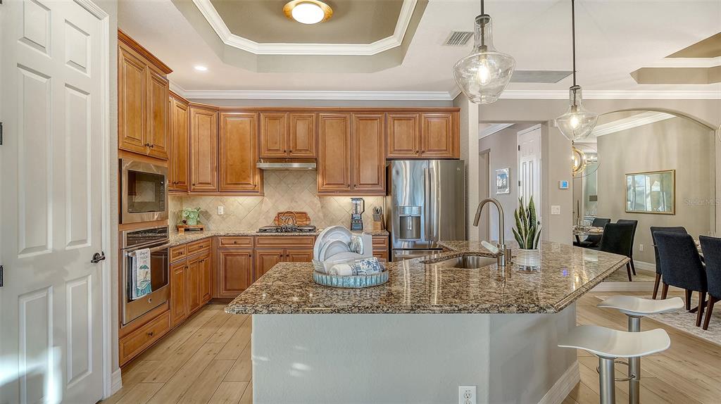 5914 Cessna Run Lakewood Ranch, FL 34211 - Photo 17 of 92 a kitchen with stainless steel appliances granite countertop a sink refrigerator and cabinets