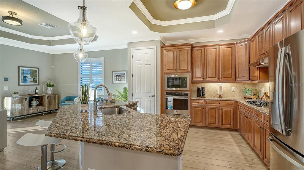 5914 Cessna Run Lakewood Ranch, FL 34211 - Photo 19 of 92 a kitchen with stainless steel appliances granite countertop a sink refrigerator and cabinets