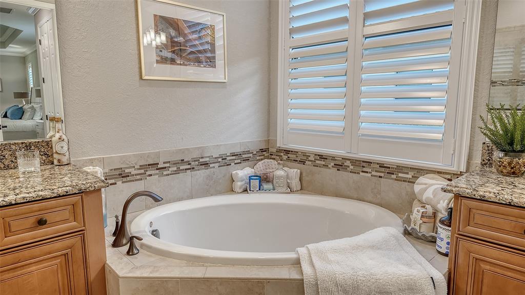 5914 Cessna Run Lakewood Ranch, FL 34211 - Photo 32 of 92 a bathroom with a granite countertop sink and a bathtub