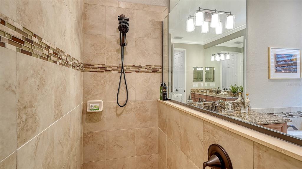 5914 Cessna Run Lakewood Ranch, FL 34211 - Photo 33 of 92 a bathroom with a granite countertop sink a mirror and a shower